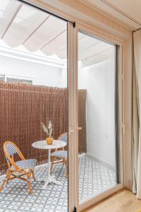 a glass door leading to a patio with a table and chairs at Malvarrosa Beach Stay! in Valencia