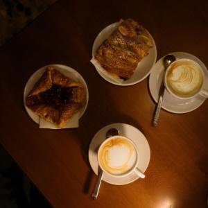 una mesa con tres platos de comida y dos tazas de café en HEATHER'S HOME 108 - Appartamento vista mozzafiato en Bassano del Grappa