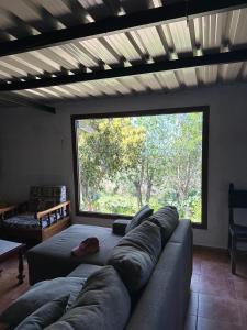a living room with a couch and a large window at Finca el Lomo in Las Palmas de Gran Canaria