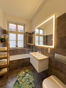 a bathroom with a sink and a toilet and a mirror at Exklusives Leipzig City Apartment Flowers in Leipzig