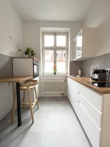 a kitchen with white cabinets and a table and a window at Exklusives Leipzig City Apartment Flowers in Leipzig