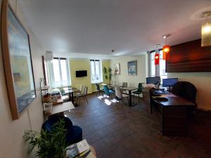 a living room with a couch and tables and chairs at Hotel Le Mistral in Cannes