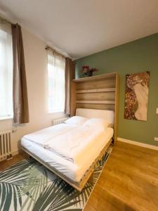 a bedroom with a large bed with a wooden headboard at Exklusives Leipzig City Apartment Flowers in Leipzig