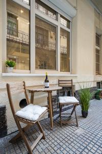 布達佩斯的住宿－Mira Holiday Apartment，一张桌子和两把椅子,并配以一瓶葡萄酒