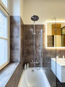 a bathroom with a shower and a tub and a sink at Exklusives Leipzig City Apartment Flowers in Leipzig