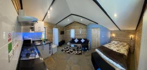 Habitación grande con cama y cocina con encimera. en Elwai Centre Wood Cabins - Couples' hideout, en Heni Village