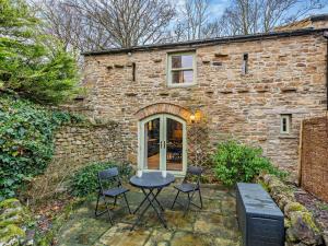 a stone house with a table and chairs in front of it at 1 Bed in Hawes 94120 in Hawes