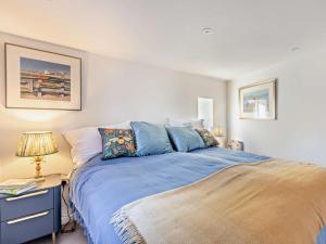 a bedroom with a bed with a blue comforter at 1 Bed in Crewkerne 94097 in Mosterton