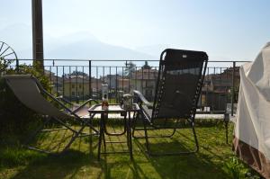 a pair of chairs and a table on a balcony at Casa Carmen Apartment Lake Como in Dongo