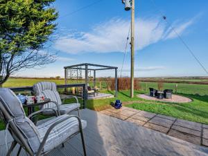 a patio with chairs and a gazebo and a grill at 1 Bed in Crackington Haven 93958 in Jacobstow