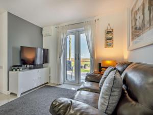 a living room with a leather couch and a television at 1 Bed in Crackington Haven 93958 in Jacobstow