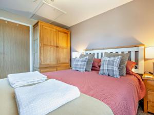 a bedroom with a large bed and a wooden cabinet at 1 Bed in Crackington Haven 93958 in Jacobstow