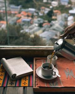 een kopje koffie op een tafel naast een raam bij Mountain Lodges of Nepal - Namche in Namche