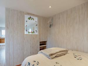 um quarto com paredes de madeira e uma cama com uma janela em 1 Bed in Bridport 94154 em Chideock