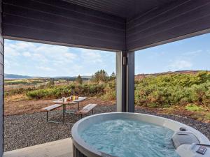 a jacuzzi tub on a patio with a table at 1 Bed in Migdale 90471 in Bonar Bridge