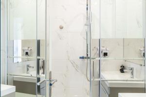 uma casa de banho com um chuveiro e um lavatório. em CMG Cannes / Plage Barrière em Cannes
