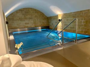 a swimming pool in a room with a brick wall at Exklusive Stadtwohnung mit Innenhofterrasse, Pool und Sauna in Bern