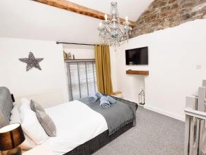 a bedroom with a bed and a chandelier at 1 Bed in Kendal 94210 in Kendal