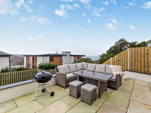 a patio with a sofa and a table and a grill at 1 Bed in Woolacombe 93920 in Woolacombe