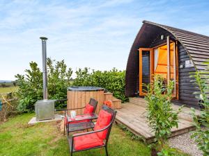 a tiny house with a deck and a table and chairs at 1 Bed in Bristol 94007 in Chew Magna