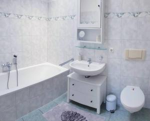 une salle de bains avec lavabo, baignoire et toilettes dans l'établissement Familienfreundliches modernes Ferienhaus nahe zum Meer und zur Pier, à Heringsdorf