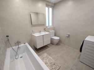 ein Badezimmer mit einer Badewanne, einem Waschbecken und einem WC in der Unterkunft San Pawl Lodge Hostel in St Paul's Bay