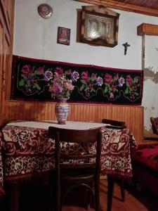 une table avec un vase de fleurs sur le mur dans l'établissement Το παραδοσιακό, à Kalambaka