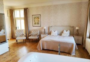 1 dormitorio con cama y bañera en Schloss Krugsdorf Golf & Hotel en Krugsdorf