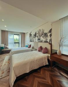 1 dormitorio grande con 2 camas y mesa en Vilas Ho Tram - Tropical Holiday 2, en Chợ Phước Hải