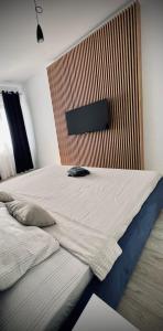 - une chambre avec un grand lit et une tête de lit en bois dans l'établissement Lakeside Oasis Apartment, à Bucarest