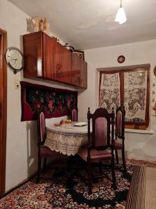 une salle à manger avec une table, des chaises et une horloge dans l'établissement Το παραδοσιακό, à Kalambaka