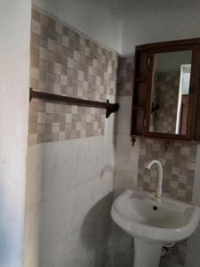 ein Bad mit einem Waschbecken und einem Spiegel in der Unterkunft Bahari Hotel in Lamu
