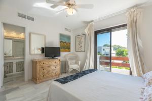 - une chambre avec un lit, une télévision et une fenêtre dans l'établissement Casa con encanto a 100m de la playa en Marbella, à Marbella