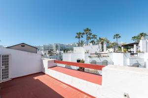 un balcón con un banco rojo en la parte superior de un edificio en Casa con encanto a 100m de la playa en Marbella, en Marbella