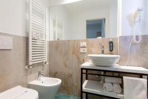 een badkamer met een wastafel en een toilet bij Hotel Grazia Riccione in Riccione