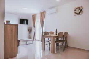 a dining room with a table and chairs at Poolside Hideout Apartments in Novalja