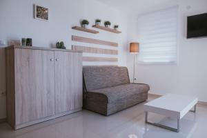 a living room with a chair and a table at Poolside Hideout Apartments in Novalja