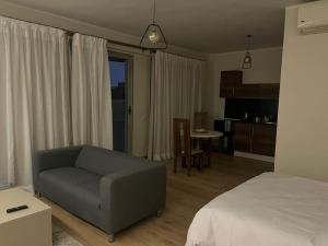 a living room with a couch and a bed at Spacious Studio Near Arkan Plaza in 6th Of October