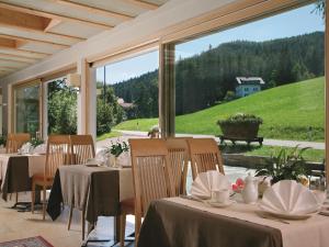 une salle à manger avec des tables et une grande fenêtre dans l'établissement Hotel Peter, à Petersberg