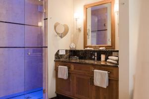 a bathroom with a sink and a shower with a mirror at Preidlhof Luxury Dolce Vita Resort in Naturno