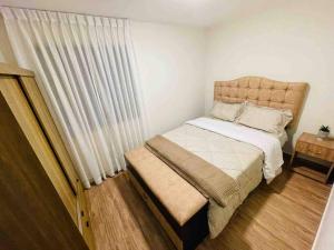 1 dormitorio con 1 cama y una ventana con cortinas en 204 Exclusivo Departamento III con estacionamiento, en Cajamarca