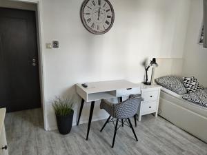 捷克賈布朗尼城的住宿－納巴斯特酒店，一间卧室配有一张桌子和一张墙上的带时钟的床。