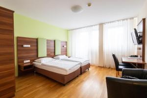 ein Hotelzimmer mit zwei Betten und einem Schreibtisch in der Unterkunft Sky Apartments Vienna in Wien + 92 Fotos