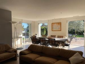 - un salon avec un canapé, une table et des chaises dans l'établissement la villa d'Ariane-piscine-jaccuzi-15 mn Mer, à Vendargues