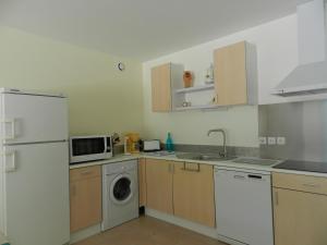 a kitchen with a refrigerator and a washer and dryer at HERMITAGE MARMANDAIS in Anzex