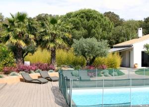 a swimming pool with chairs next to a house at la villa d'Ariane-piscine-jaccuzi-15 mn Mer in Vendargues