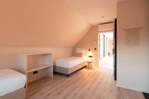 een slaapkamer met 2 bedden en een kamer met een gang bij Villa Midi in De Haan