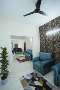 een woonkamer met blauwe banken en een plafondventilator bij Yellow Bells Serviced Apartments Hitech City in Hyderabad