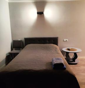 Un dormitorio con una cama grande y una mesa al lado. en Новая квартира апартаменты в центре, en Izmaíl