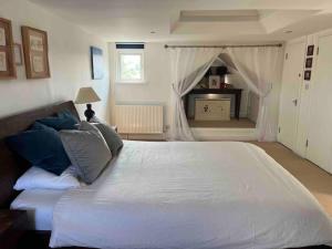 - une chambre avec un grand lit blanc et des oreillers bleus dans l'établissement Luxury 4 bedroom house in London featured on TV, à Londres